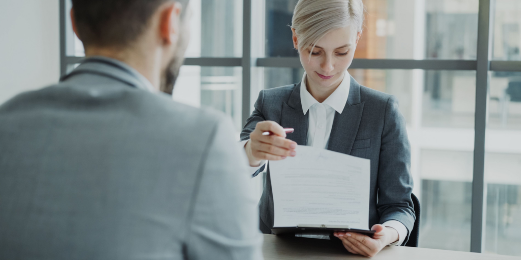 Una responsable de recursos humanos revisa con un nuevo empleado la documentación de su contrato de trabajo