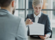 Una responsable de recursos humanos revisa con un nuevo empleado la documentación de su contrato de trabajo